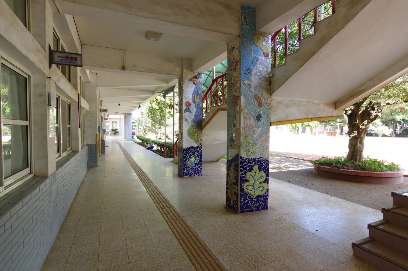 西嶺國小走廊上鑲嵌馬賽克拼貼的柱子,色彩繽紛 A mosaic-tiled column along the school corridor, bright with colour