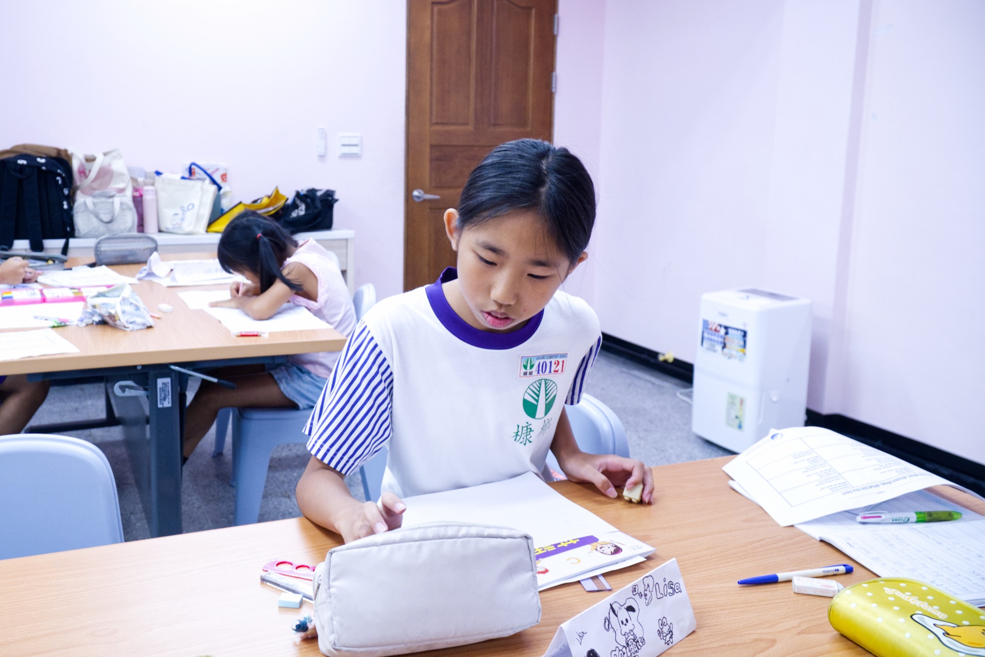 A camper works through an English reading and writing packet at her desk