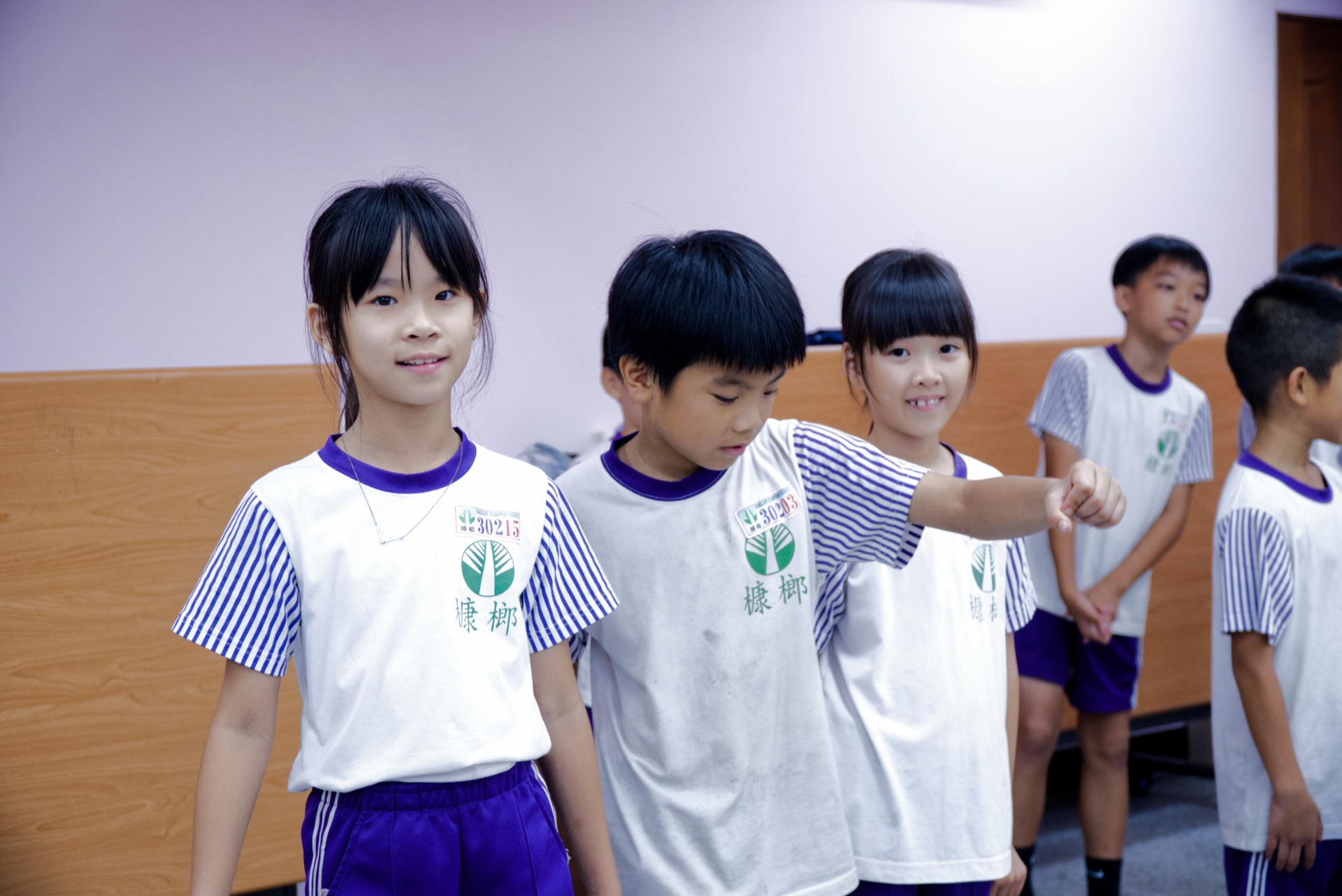 Campers line up for an English speaking and pointing game